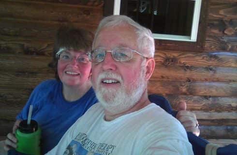 Man with white t-shirt sitting next to woman with blue t-shirt holding green water bottle