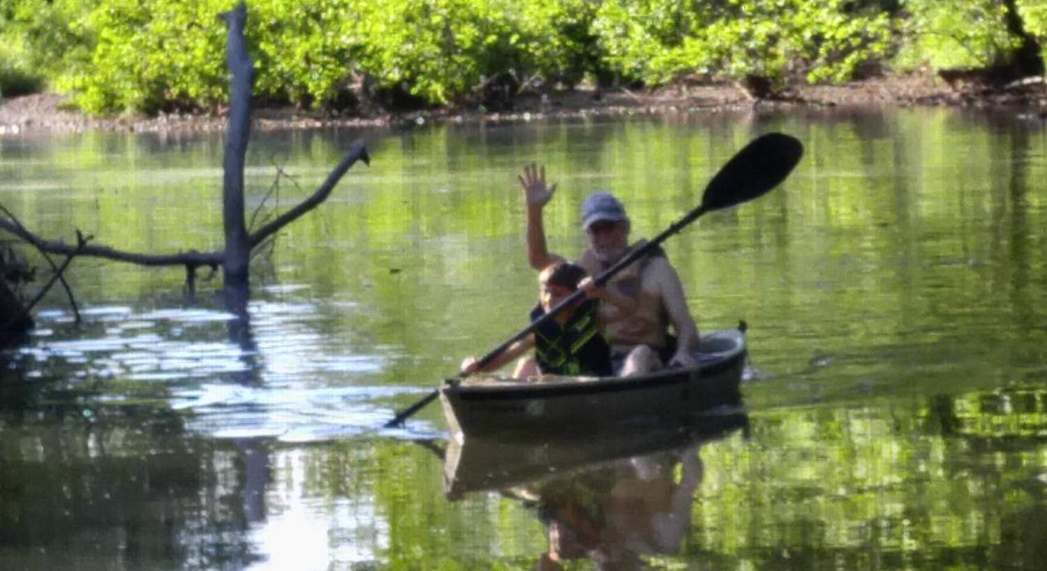 Man and boy kayaking on the river