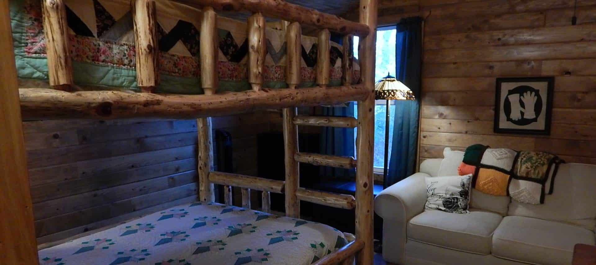 Bedroom with carpet, wood paneling on the walls, wooden bunk bed, and love seat